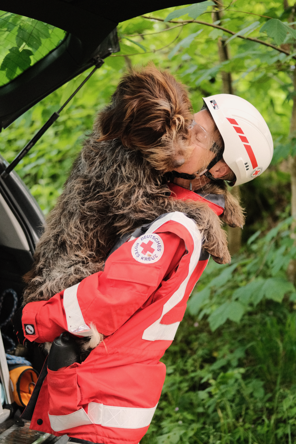 Frau vom deutschen roten Kreuz mit Hund auf dem Arm