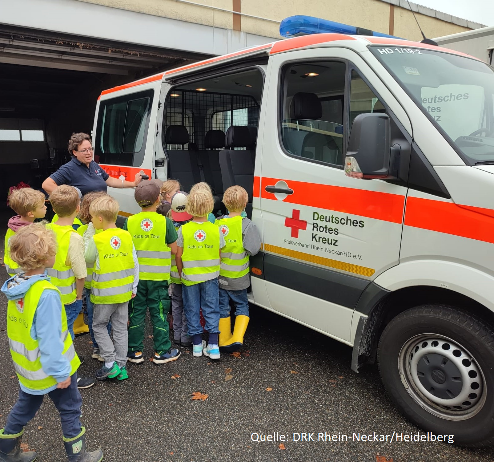 Eine Gruppe Kinder steht vor einem Rettungswagen des Deutschen Roten Kreuzes