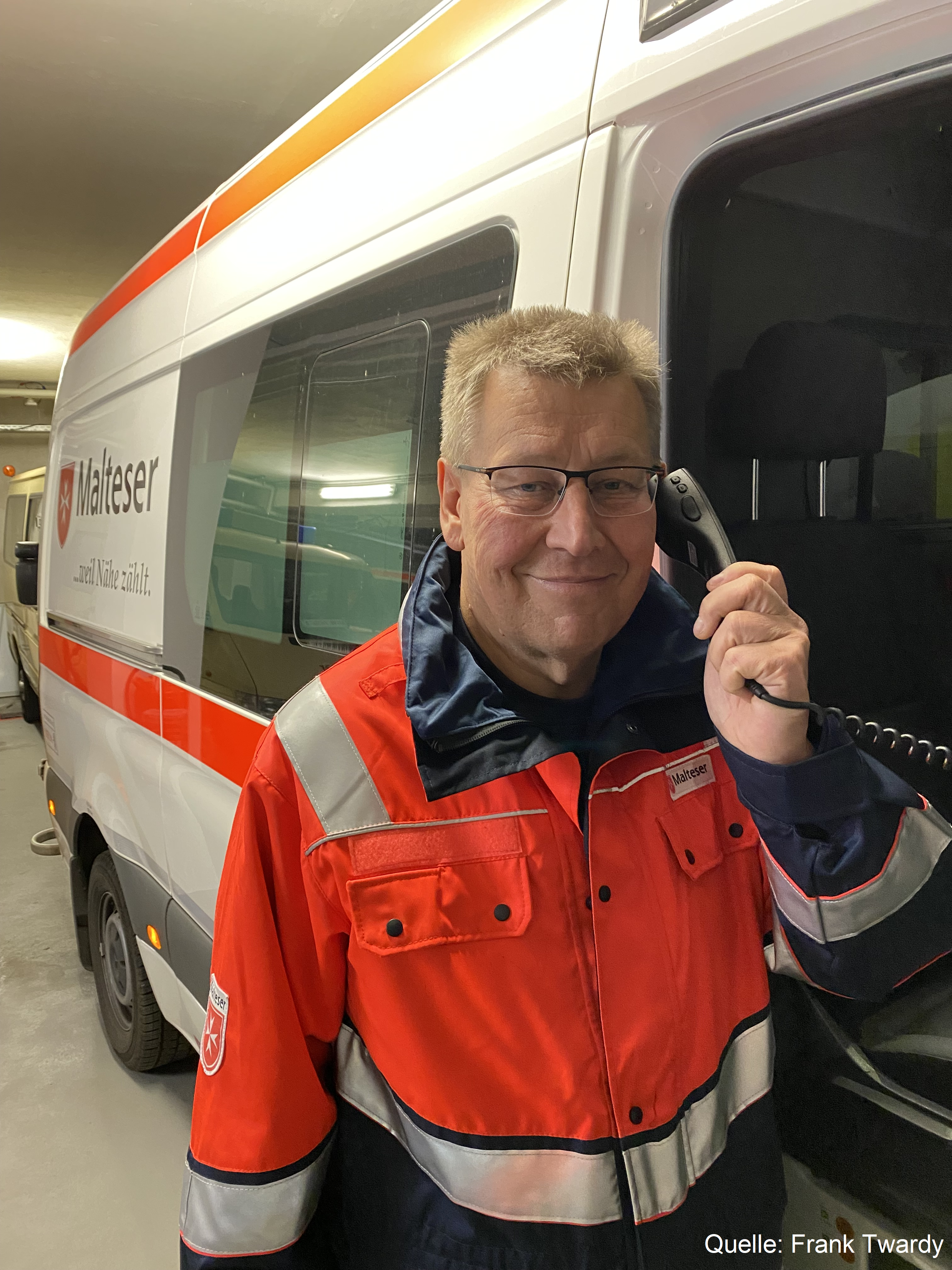 Frank Twardy in Malteser Uniform vor Krankenwagen