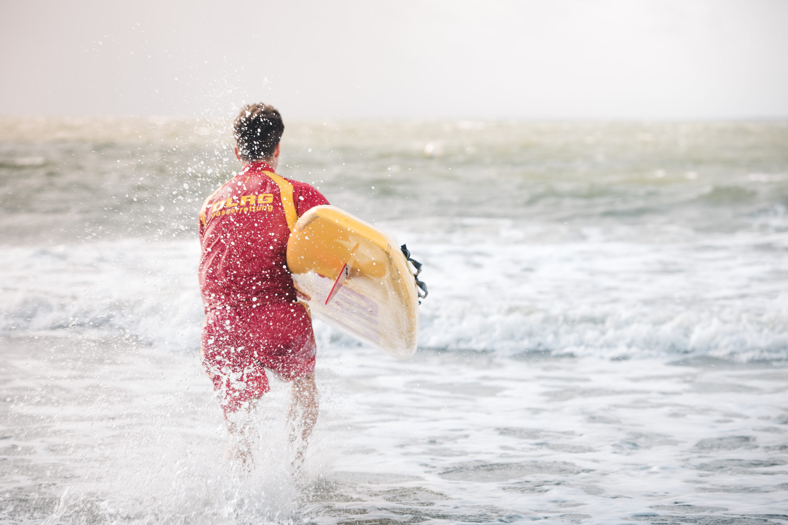 Battling wind and waves: well equipped, they head out into the surf.